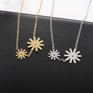Detail of gold and silver daisy flower pendants on stainless steel cross chains
