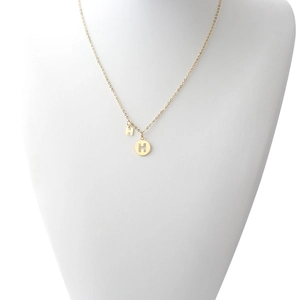 Detail of gold titanium steel necklace featuring a letter H and hollow sun flower pendant