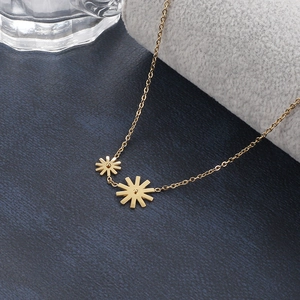 Detailed view of golden daisy pendants on a delicate cross chain for women