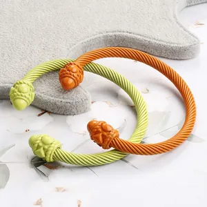 Detail of twisted cable cuff bracelets in orange and lime green enamel on gray felt