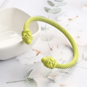 Close-up of grass green enamel twist cable cuff bracelet with relief ball ends