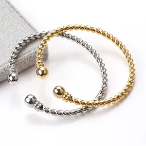 Close-up of twisted rope texture and spherical ends on gold and silver steel bangles