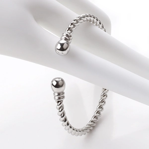 Macro detail of silver twisted cable bracelet with polished end beads on a hand model
