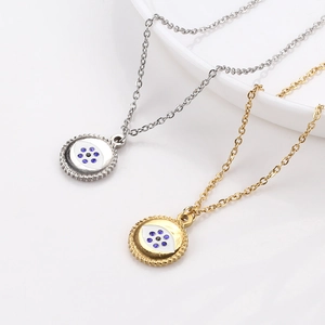 Gold and silver evil eye necklaces with rhinestone accents on a white porcelain bowl