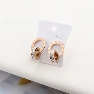 Close-up of rose gold roman numeral earrings with crystal inlay on stainless steel studs