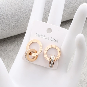 Detail of rose gold Roman numeral earrings with cubic zirconia on a jewelry model