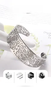 Detail view of silver hollowed-out floral pattern on a titanium steel bangle bracelet