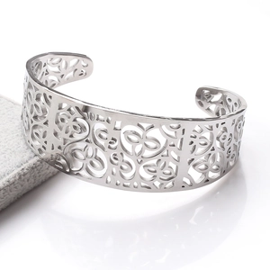 Detailed macro view of an open stainless steel cuff bracelet with floral cutout patterns