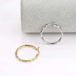 Detailed view of twisted rope texture on gold and silver stainless steel hoop earrings