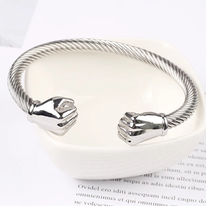 Detailed macro of stainless steel cable twist bracelet with unique fist-shaped ends