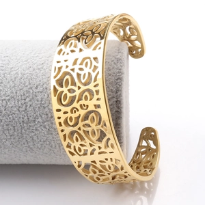 Detailed view of wide golden stainless steel cuff bracelet with hollow floral patterns