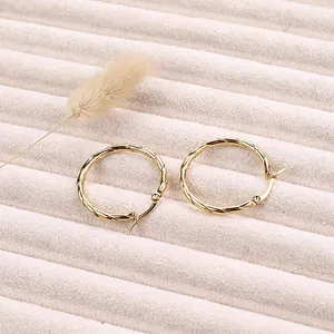 Minimalist 18K gold-plated stainless steel twisted hoop earrings on a jewelry tray