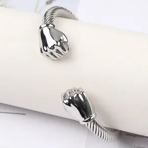 Close-up of silver stainless steel twisted cable bracelet featuring solid fist charms