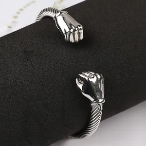 Detailed macro view of silver twisted cable stainless steel bracelet with fist motifs