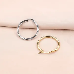 Detailed view of gold and silver twisted rope hoop earrings with click-top closure