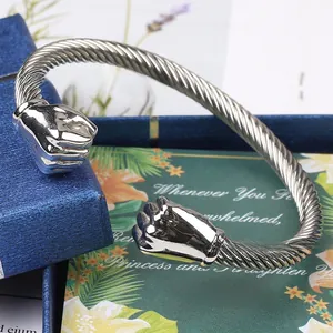 Macro detail of silver stainless steel twisted cable bracelet with fist ends on gift box