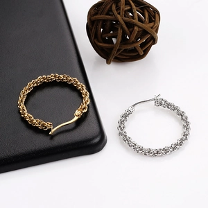 Detail of twisted spiral gold and silver hoop earrings with spring hinge closure