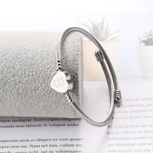 Détail du bracelet câble torsadé argenté avec un pendentif cœur poli gravé de la lettre B