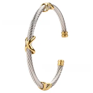 Detail of silver cable twist cuff bracelet with gold X accents and cylinder end caps