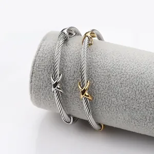 Detail showing gold and silver cable bracelets with X-shaped crossover clasp on display
