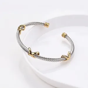 Gold and silver spiral cable bangle with X-shaped crossover design in stainless steel