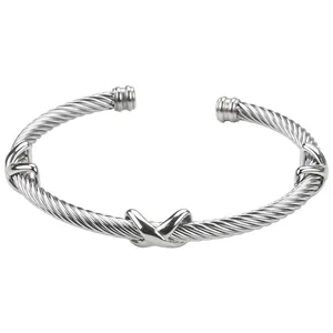 Detailed macro view of silver cable cuff bracelet featuring three polished X symbols