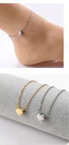 Detail of polished heart pendant anklet in gold and silver finish for beach styling