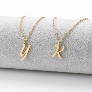 Macro detail of gold-plated stainless steel anklets with K and y letter pendants