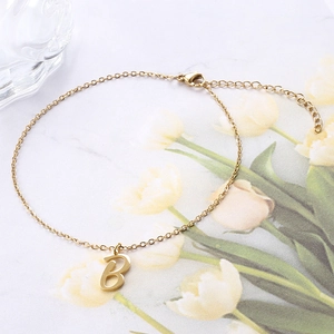 Close-up of golden stainless steel anklet with bold letter B pendant and lobster clasp