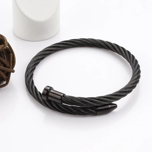 Détail du bracelet câble torsadé noir en acier avec tête de clou et pointe conique