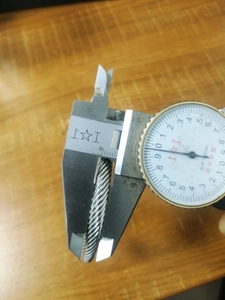 Detailed measurement of stainless steel twisted ring wire diameter with a caliper