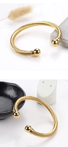 Macro view of gold twisted cable stainless steel bangle with spherical ends