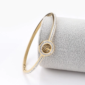 Detailed close-up of tree of life bracelet with gold plating and sparkling crystals