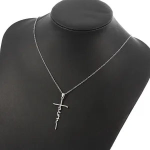 Vista dettagliata della collana con ciondolo a croce faith dorata su manichino nero