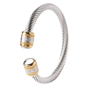 Macro shot of silver cable twisted bangle with gold ends and white onyx stone inlays