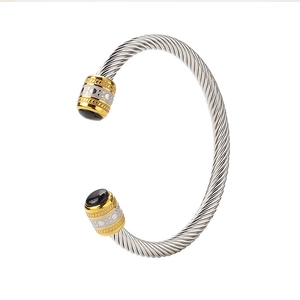 Detail of twisted cable steel bracelet with gold accents and black onyx gemstones