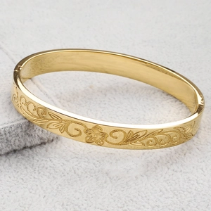 Bracelet jonc de 8mm en acier doré avec d'élégants motifs floraux gravés