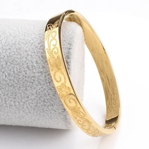 Vue détaillée d'un bracelet ouvert doré de 8mm avec gravures de fleurs et de vignes