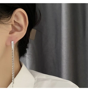 Close-up of elegant long silver tassel earrings with shimmering cubic zirconia stones