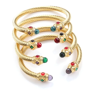 Detailed stack of four gold cable twisted bracelets with multi-color gemstone ends