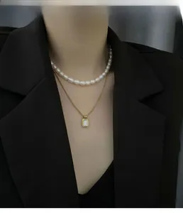 Close-up of double-layer necklace with freshwater pearls and rectangular shell pendant