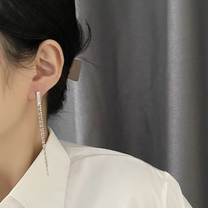 Elegant silver long tassel earrings with sparkling zircons worn with a white shirt