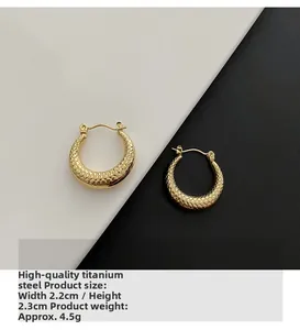 Detailed view of gold titanium steel hoop earrings featuring 2.2cm snake scale texture