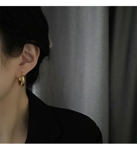Close-up of elegant gold hoop earrings worn by a model for a sophisticated look