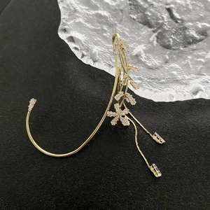 Detailansicht der goldener Blumen-Ohrmanschette mit Zirkon-Blüten und langen Quasten