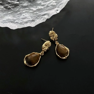 Retro tiger eye stone teardrop earrings with hammer-textured gold finish on black background