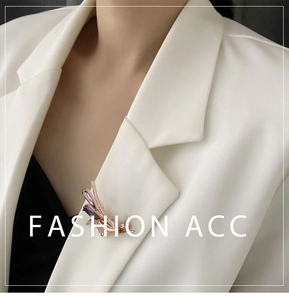 Détail d'une broche plaquée or avec zircon violet sur le revers d'un blazer blanc