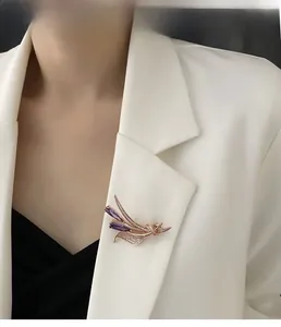 Détail d'une broche fleur en zircon violet fixée sur le revers d'un tailleur blanc