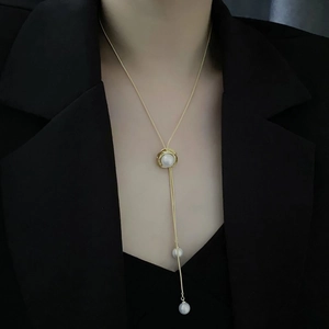 Collier lariat en perles dorées ajustables sur mannequin avec long pendentif à pampilles