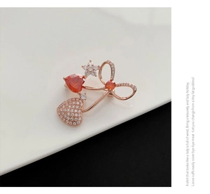 Detail of cherry brooch with red heart gemstone, sparkling diamonds and a bow tie accent